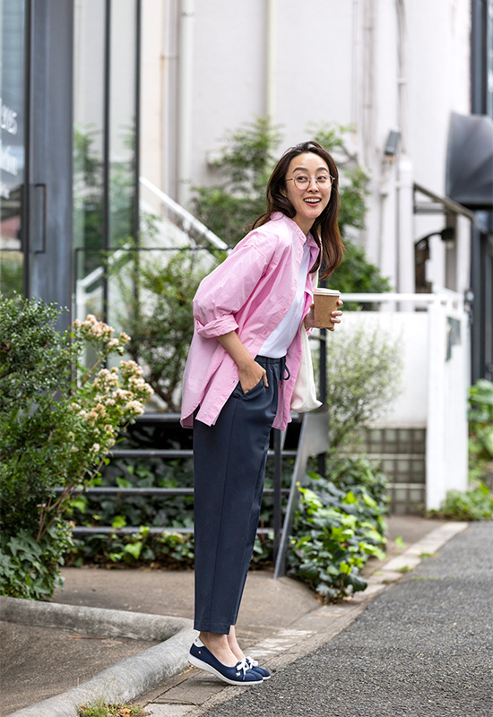 春のオフィスファッションに合う甲浅のネイビー軽量スニーカーとピンクシャツの着こなし