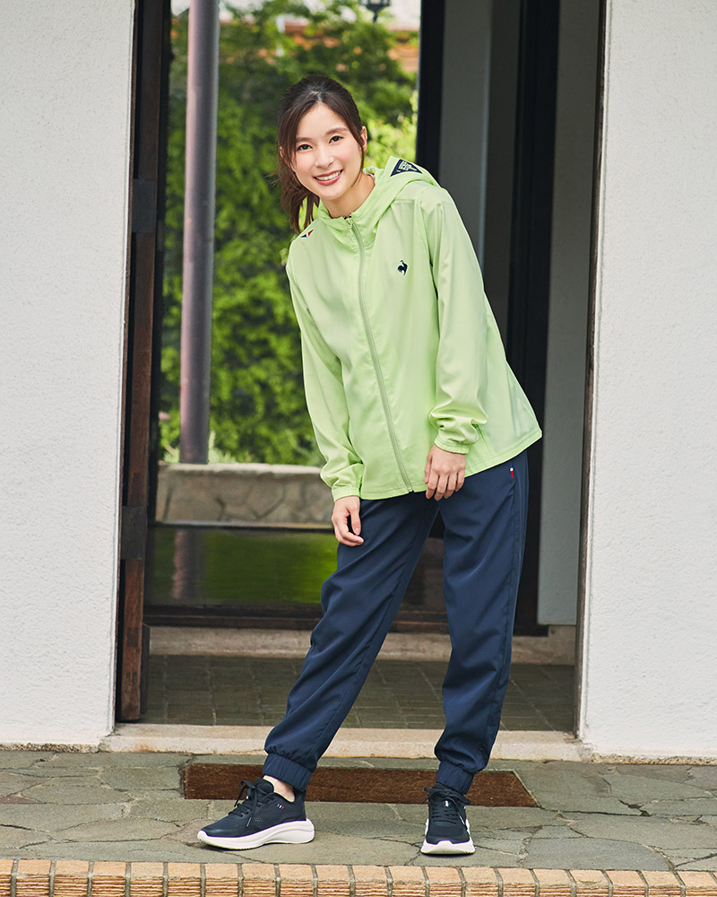 ルコックスポルティフのグリーンのクロスジャケットとネイビーパンツを着用した芳根京子さん