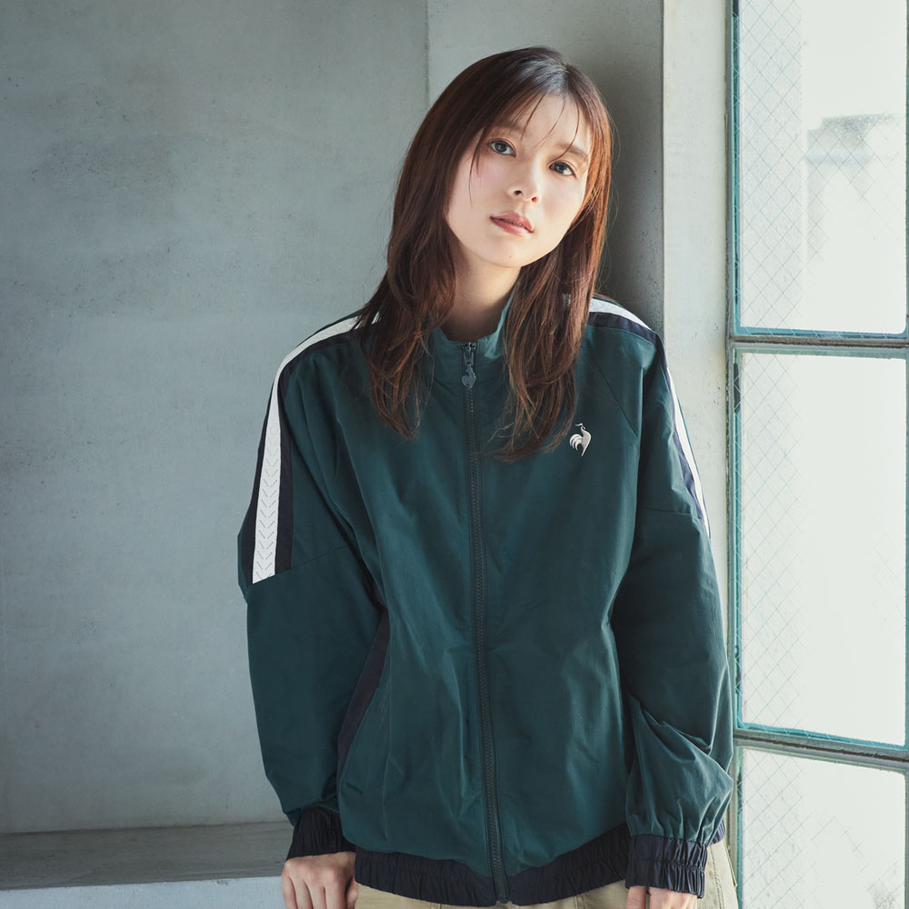 肩にラインが入ったグリーンのフルジップクロスジャケットを着てリラックスする芳根京子さん