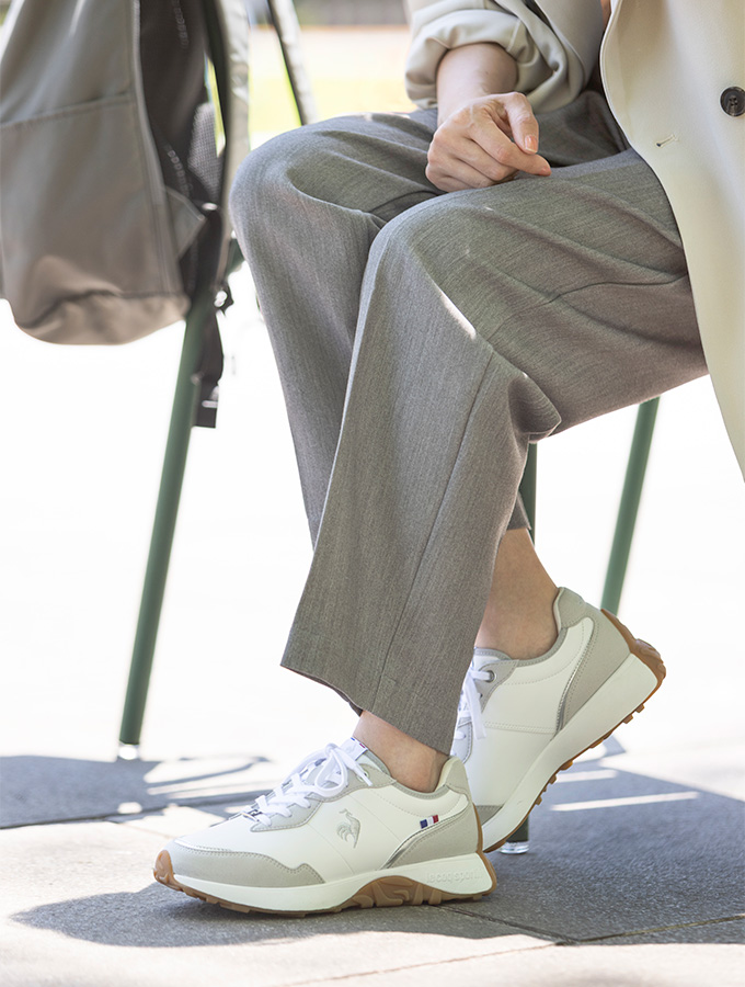 白のヒールスニーカーにジャケットとスラックスを合わせた40代女性の通勤コーディネート