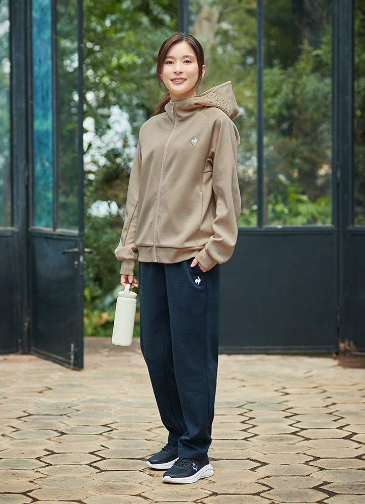 ベージュカラーのアクティブスウェットジャケットとネイビーパンツを着こなす芳根京子さん