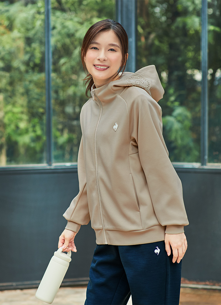 ベージュカラーのアクティブスウェットジャケットとネイビーパンツを着こなす芳根京子さん